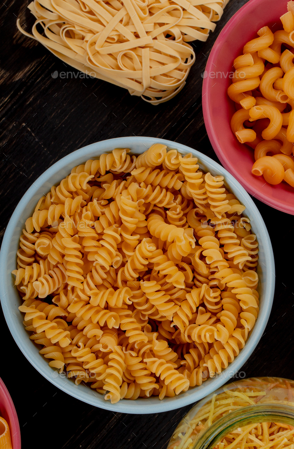 top view of different types of macaroni as rotini, cavatappi, spaghetti, tagliatelle on wooden